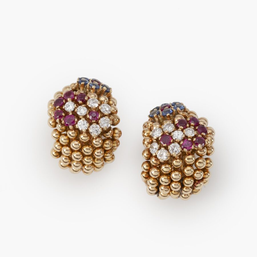 A pair of eighteen carat gold earclips model ‘Pelouse Hawaii’, set with diamonds, rubies and sapphires. Signed Van Cleef & Arpels, made ca 1950.