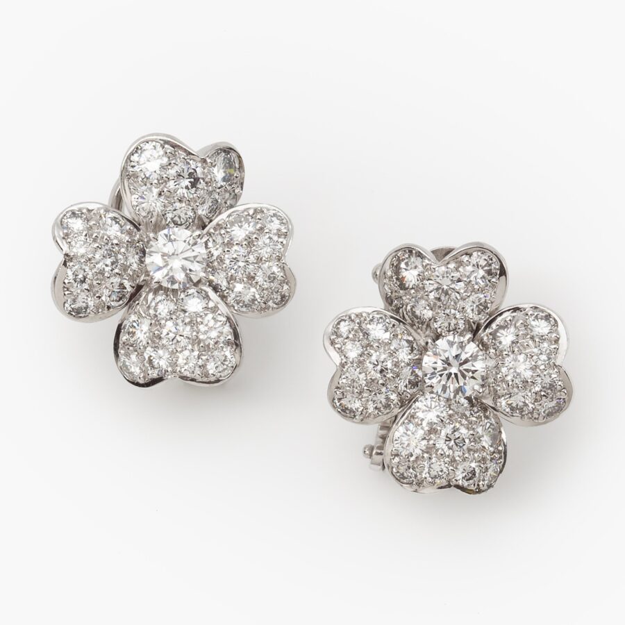 A pair of platinum 'Cosmos' clip earrings, each designed as a flower, set with brilliant cut diamonds. Signed Van Cleef & Arpels, New York and numbered.