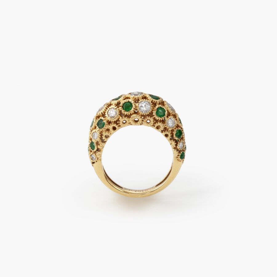 An eighteen carat yellow gold ring of bombé design, set with emeralds and diamonds. Signed Van Cleef & Arpels and numbered. Made in Paris and dated 1975.
