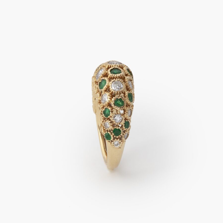 An eighteen carat yellow gold ring of bombé design, set with emeralds and diamonds. Signed Van Cleef & Arpels and numbered. Made in Paris and dated 1975.