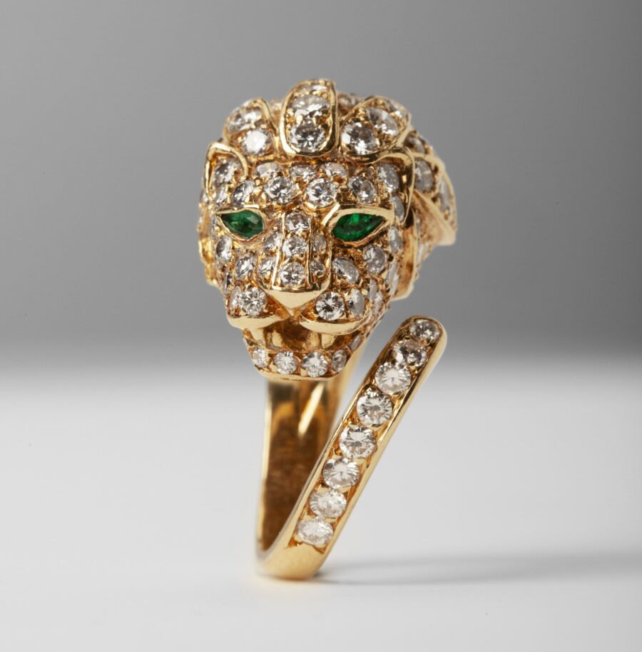 An eighteen carat yellow gold ring designed as a lion’s head, set with diamonds and with emerald eyes. Made by Georges Lenfant, in Paris, ca 1970.