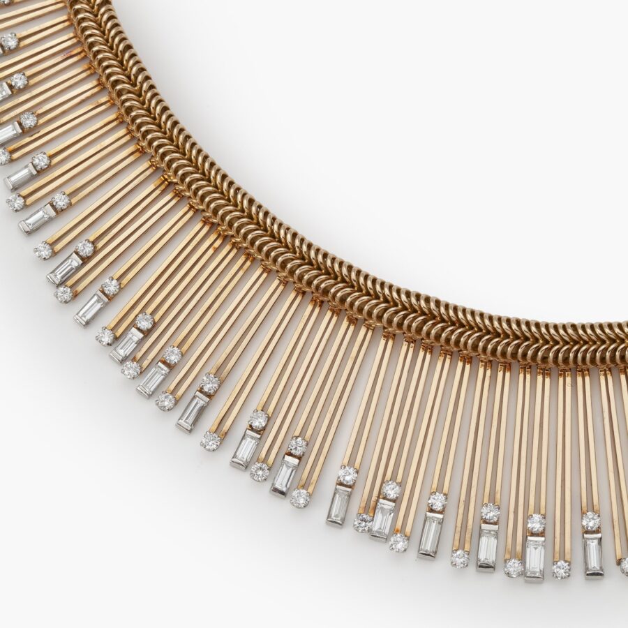 An eighteen carat yellow gold and platinum Retro necklace designed as a chain supporting a fringe set with diamonds. Signed Sterlé Paris. Made circa 1950.