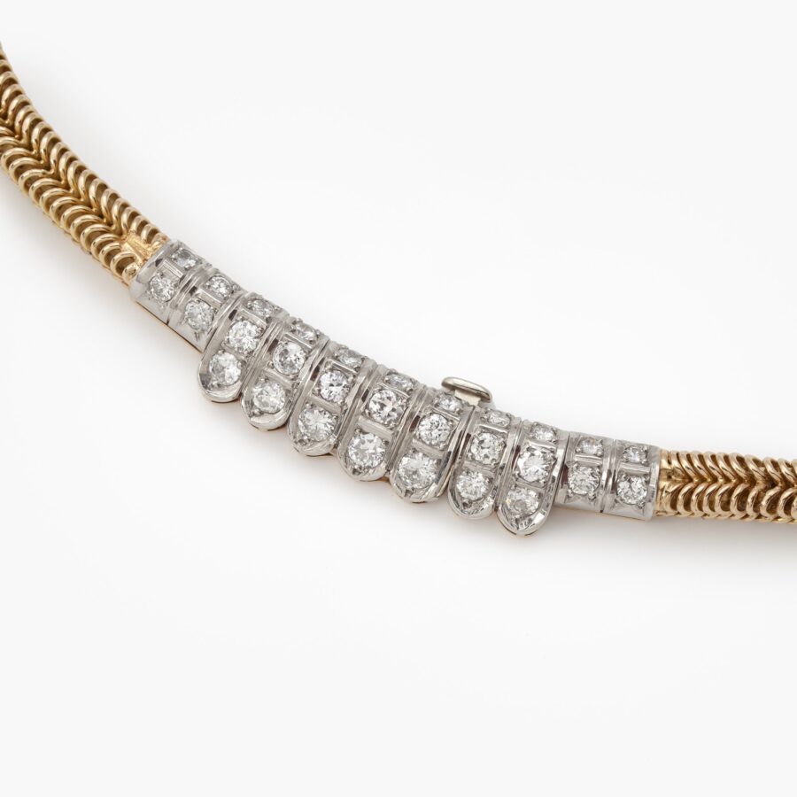 An eighteen carat yellow gold and platinum Retro necklace designed as a chain supporting a fringe set with diamonds. Signed Sterlé Paris. Made circa 1950.