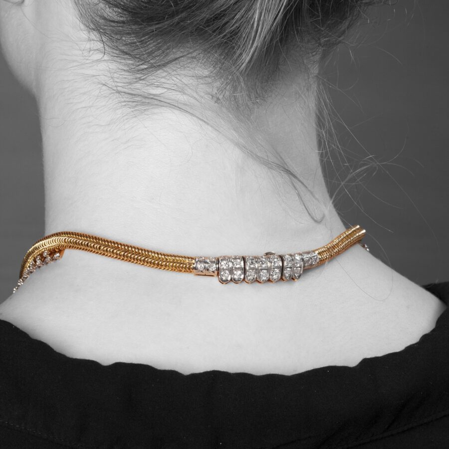 An eighteen carat yellow gold and platinum Retro necklace designed as a chain supporting a fringe set with diamonds. Signed Sterlé Paris. Made circa 1950.