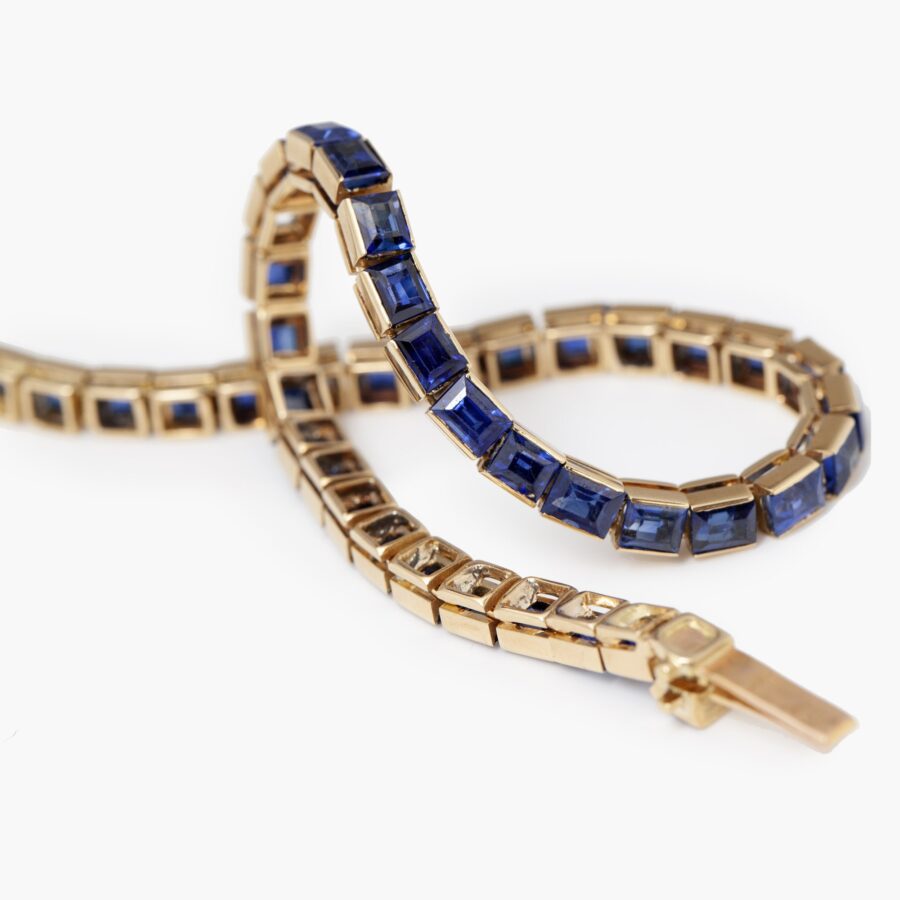 An eighteen carat rosé gold line bracelet set with baguette cut blue sapphires. Made by Cartier in Paris in 1918 and numbered. With IAJA Expertise report.