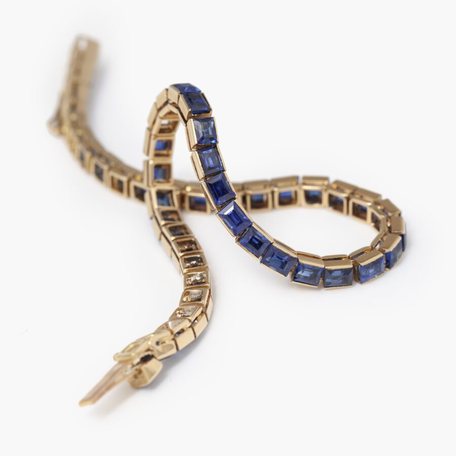 An eighteen carat rosé gold line bracelet set with baguette cut blue sapphires. Made by Cartier in Paris in 1918 and numbered. With IAJA Expertise report.