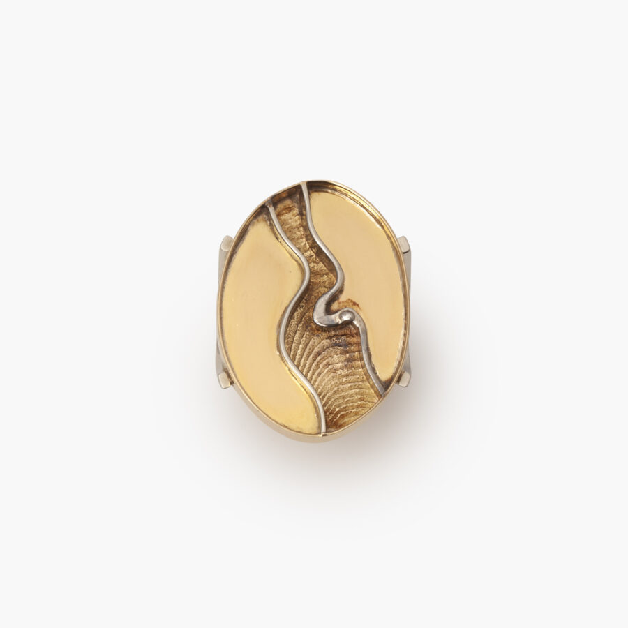 An eighteen carat yellow and white gold ring designed as a large oval head with sepia structure. Signed Arnaldo Pomodoro (Italy, 1926). Dated 1963.