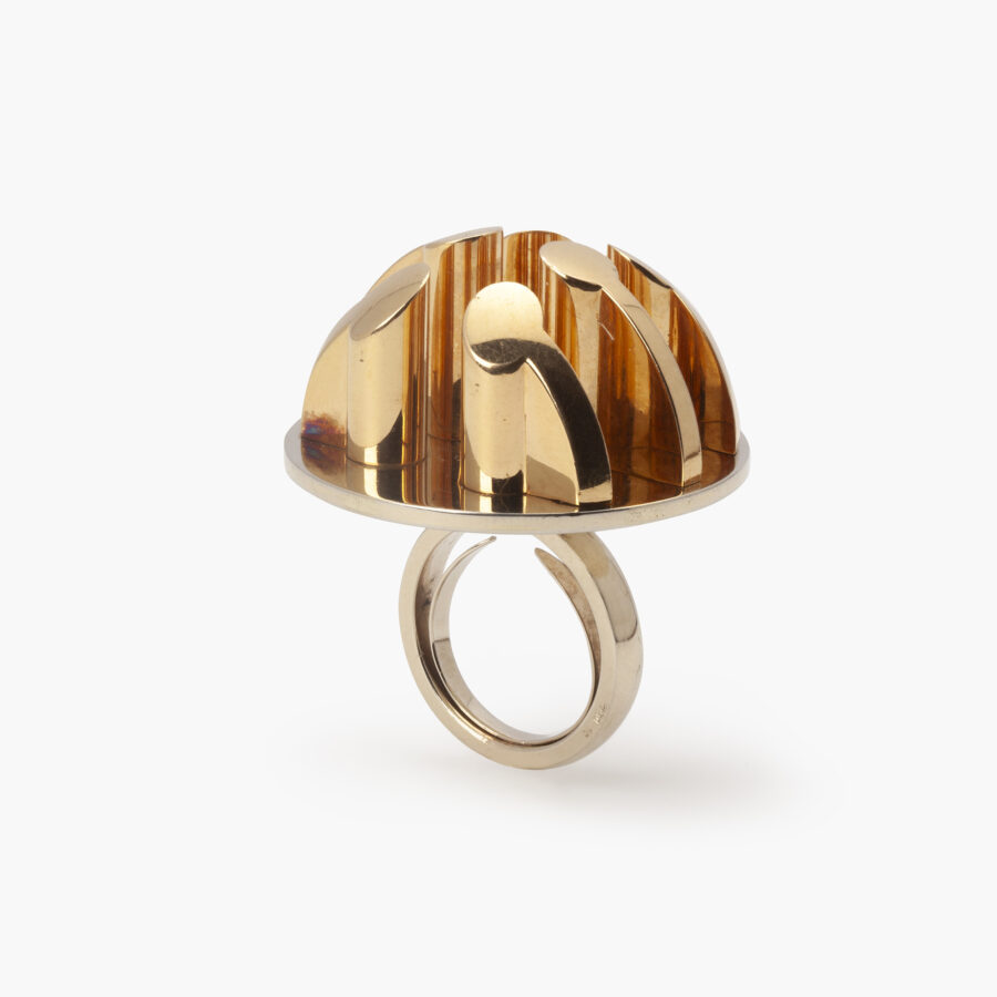 An eighteen carat yellow and white gold ring, six pillars are mounted on the round base. Signed Arnaldo Pomodoro, Italy. Numbered and dated 1970. 