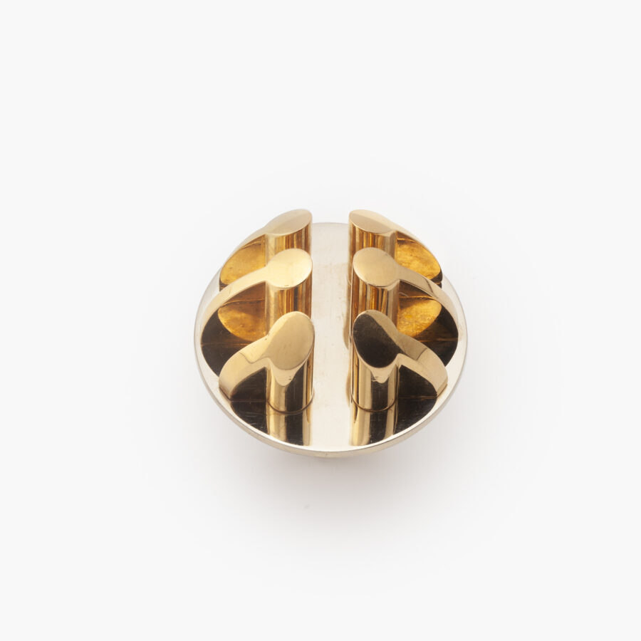 An eighteen carat yellow and white gold ring, six pillars are mounted on the round base. Signed Arnaldo Pomodoro, Italy. Numbered and dated 1970. 