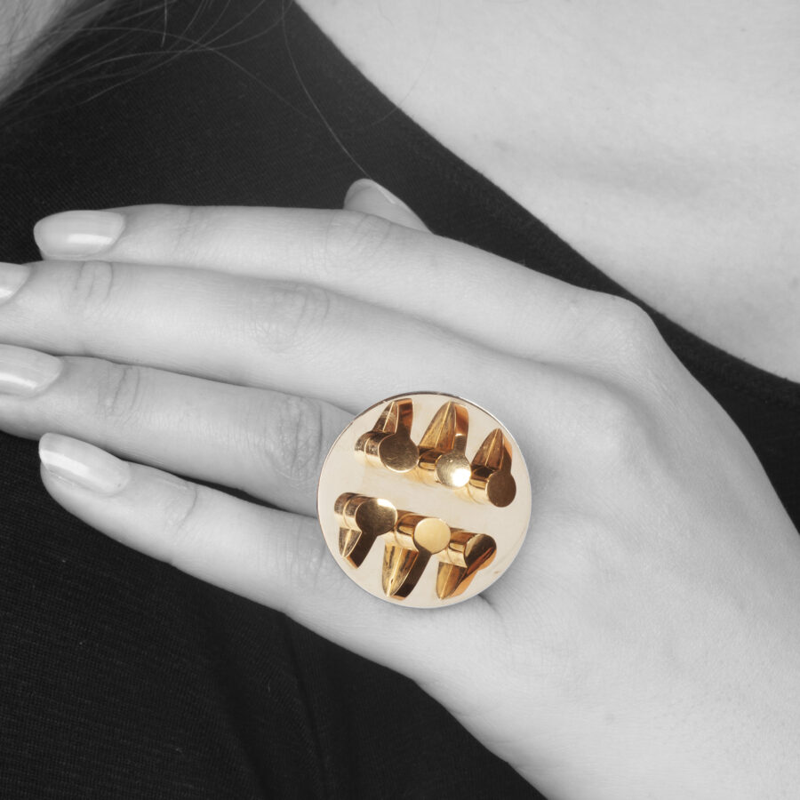 An eighteen carat yellow and white gold ring, six pillars are mounted on the round base. Signed Arnaldo Pomodoro, Italy. Numbered and dated 1970. 