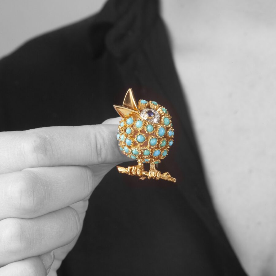 An eighteen carat yellow gold bird brooch set with turquoise, blue sapphire and diamonds. Signed Van Cleef & Arpels, Paris. Numbered and dated 1964. 