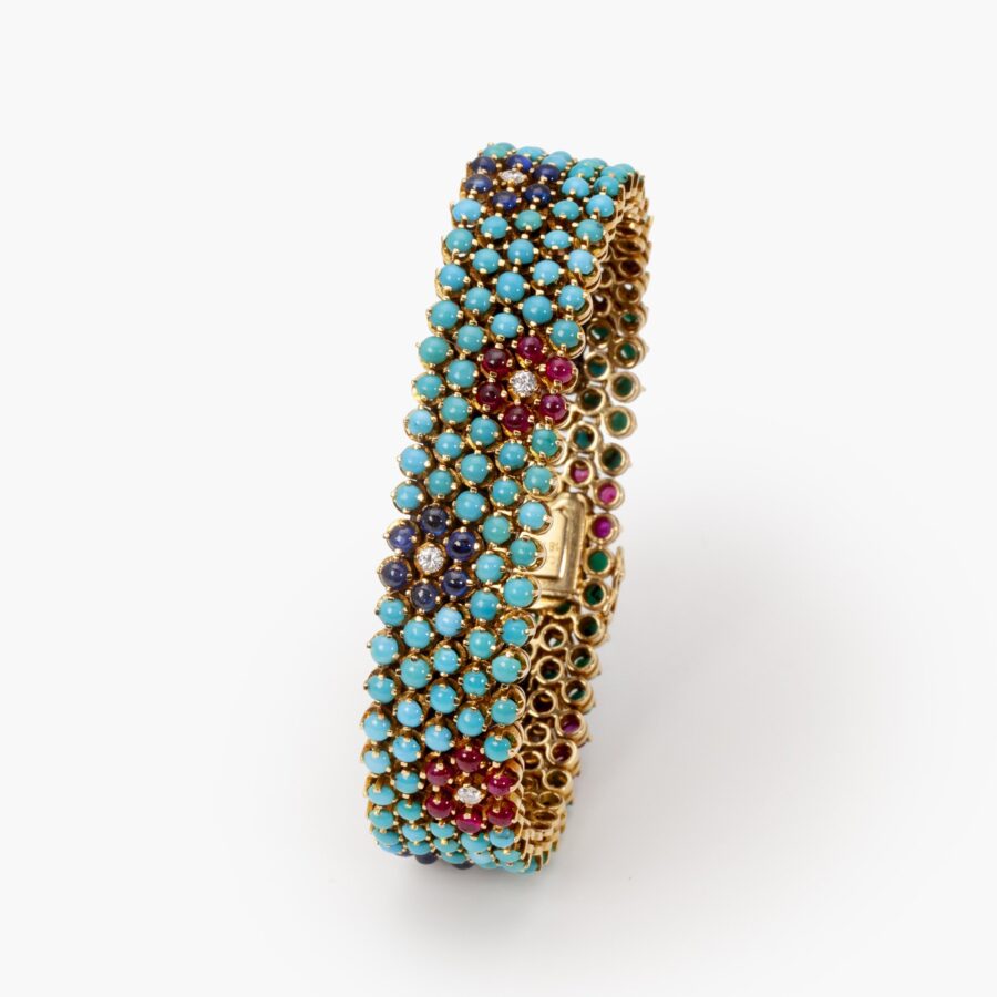 An eighteen carat yellow gold bracelet, set with turquoise, rubies, blue sapphires and diamonds. Signed Cartier, made in Italy, ca 1960 and numbered.