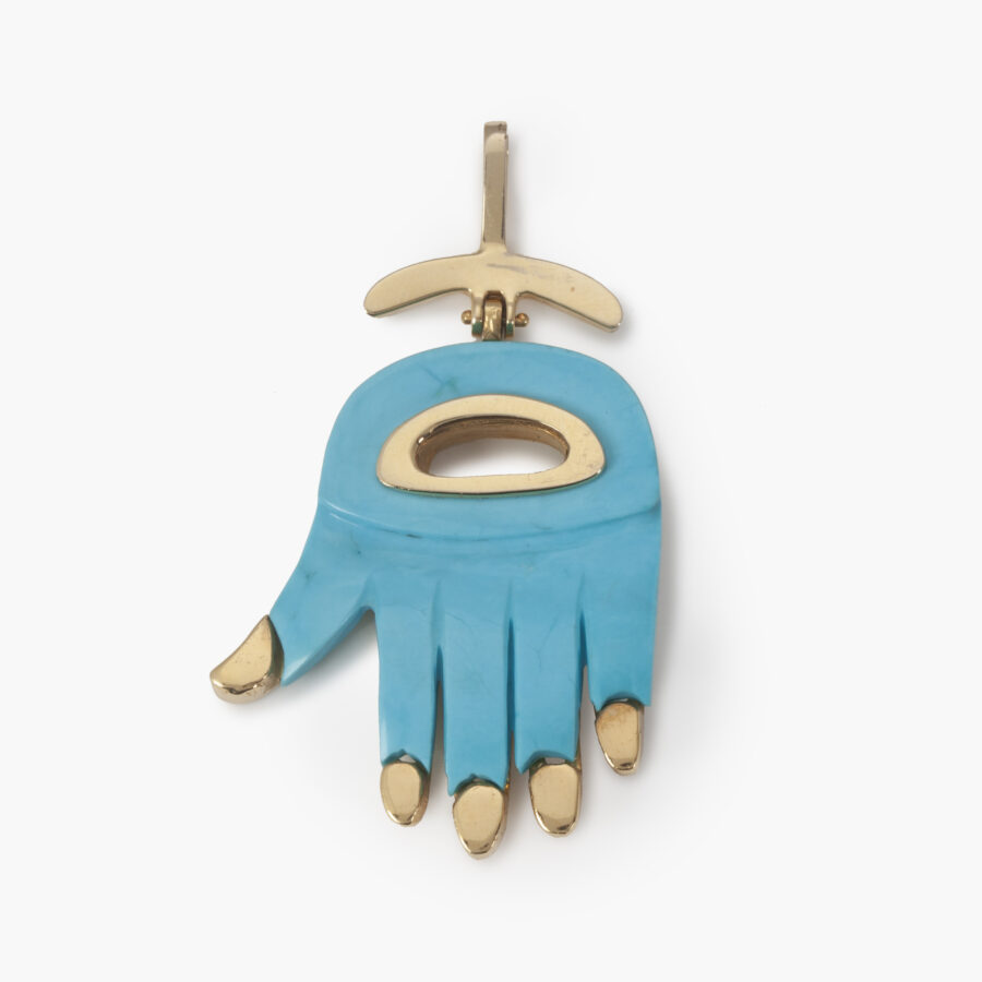 An eighteen carat yellow gold “Hamsa” pendant designed as a hand, inleyed with turquoise. Signed Aldo Cipullo, New York, ca 1970.