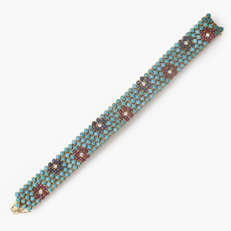 An eighteen carat yellow gold bracelet, set with turquoise, rubies, blue sapphires and diamonds. Signed Cartier, made in Italy, ca 1960 and numbered.