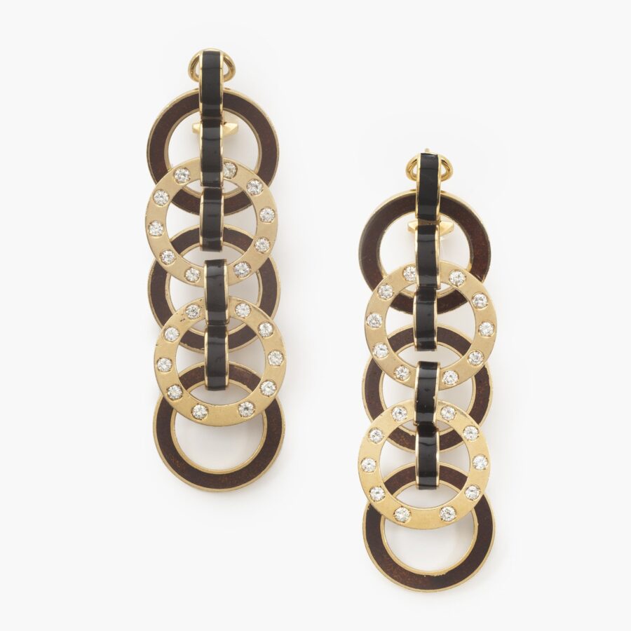 A pair of eighteen carat yellow gold earrings comprising brown enameled and diamond set rings. Signed Christian Dior, and numbered, made ca 1980.