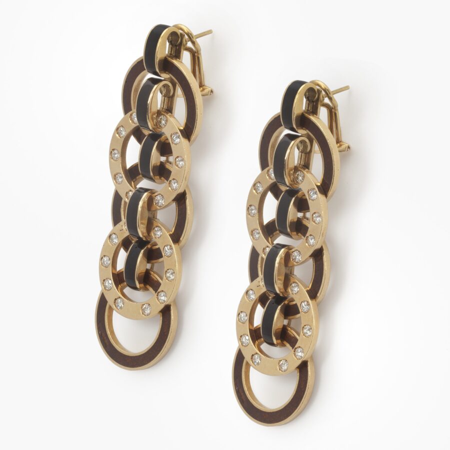 A pair of eighteen carat yellow gold earrings comprising brown enameled and diamond set rings. Signed Christian Dior, and numbered, made ca 1980.