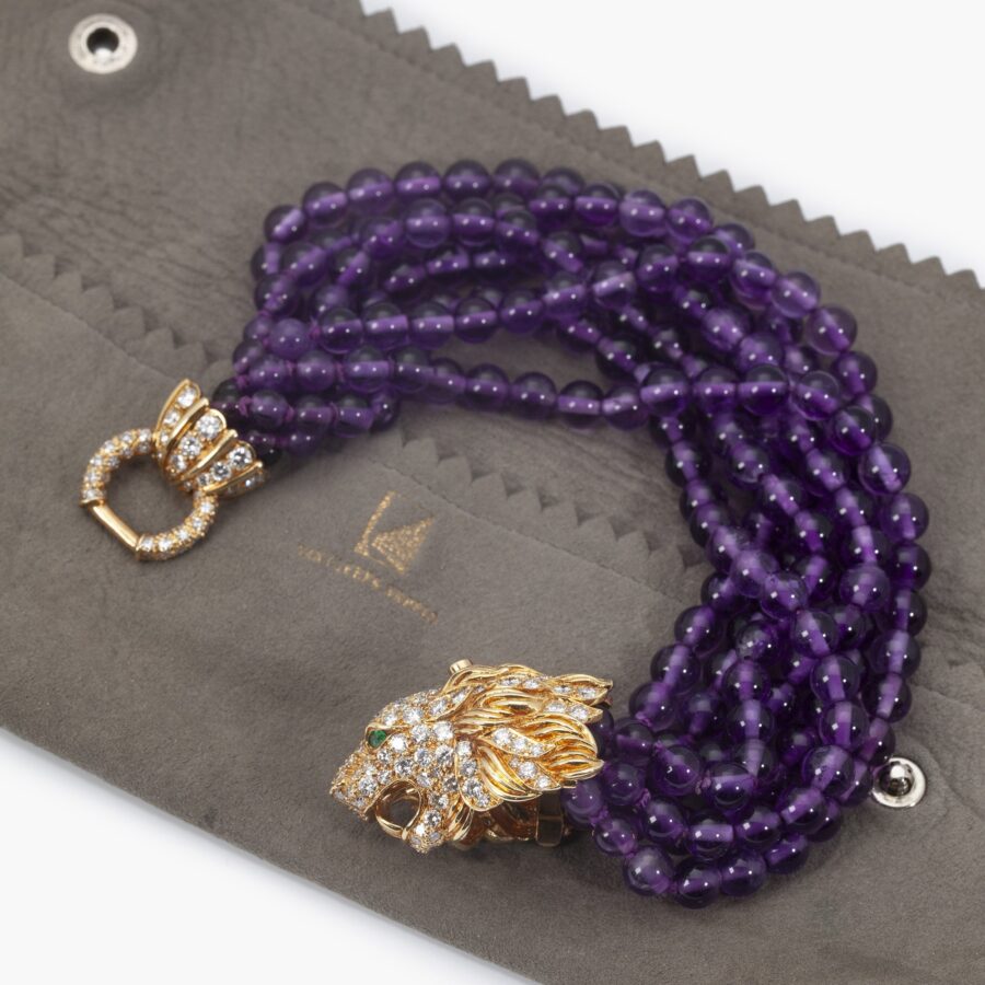 A yellow gold bracelet ‘Lion Barquerolles’ designed as a lion’s head clasp on amethyst beads. Signed Van Cleef & Arpels, New York. Numbered and dated 1971.