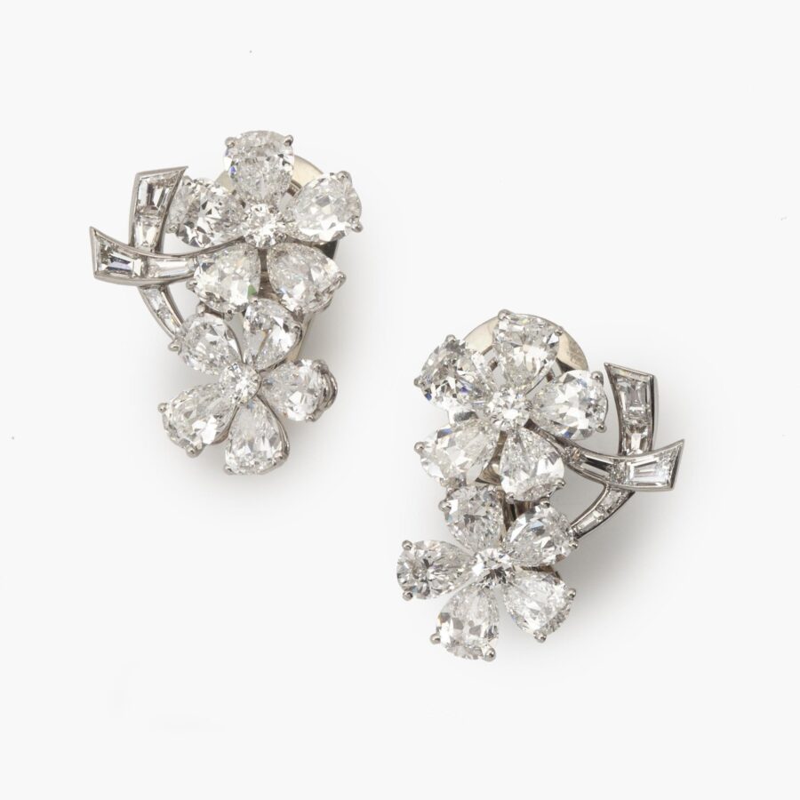 A pair of platinum and eighteen carat white gold clip earrings, each designed as two diamond set flowers. Signed Van Cleef & Arpels, Paris and numbered. 