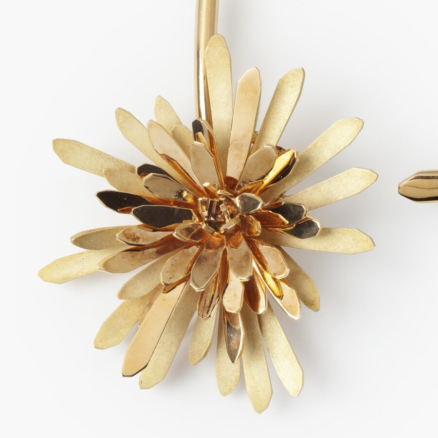 An eighteen carat yellow gold choker collar from the L’Arcade series with a large detachable flower wearable as a brooch. Signed Chaumet, Paris, ca 1970.