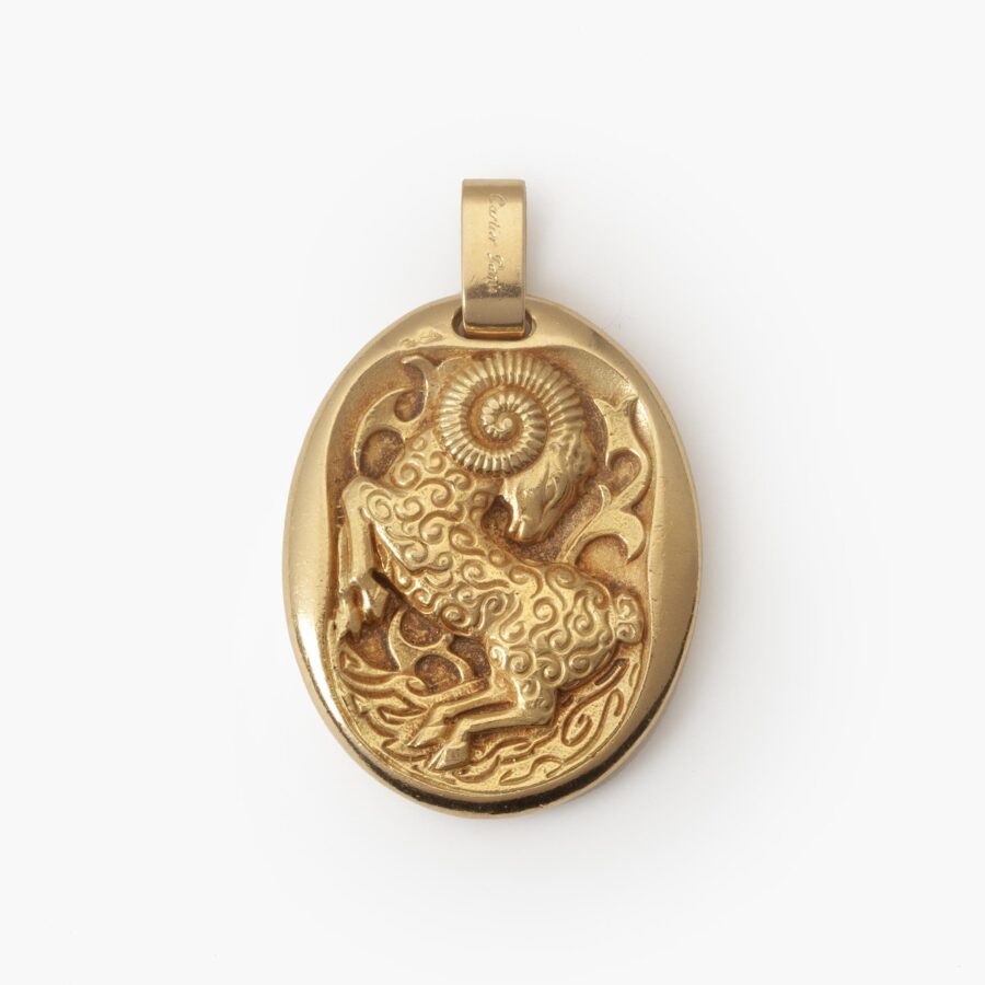 An eighteen carat yellow gold oval pendant, with the zodiac sign Aries. Signed Cartier Paris, made ca 1970 by Georges Lenfant, Paris, and numbered.