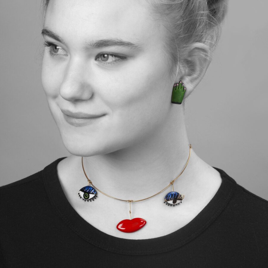 An eighteen carat yellow gold necklace with three pendants forming a face, with two pairs of matching earrings. Signed Niki de Saint Phalle, dated 1973.