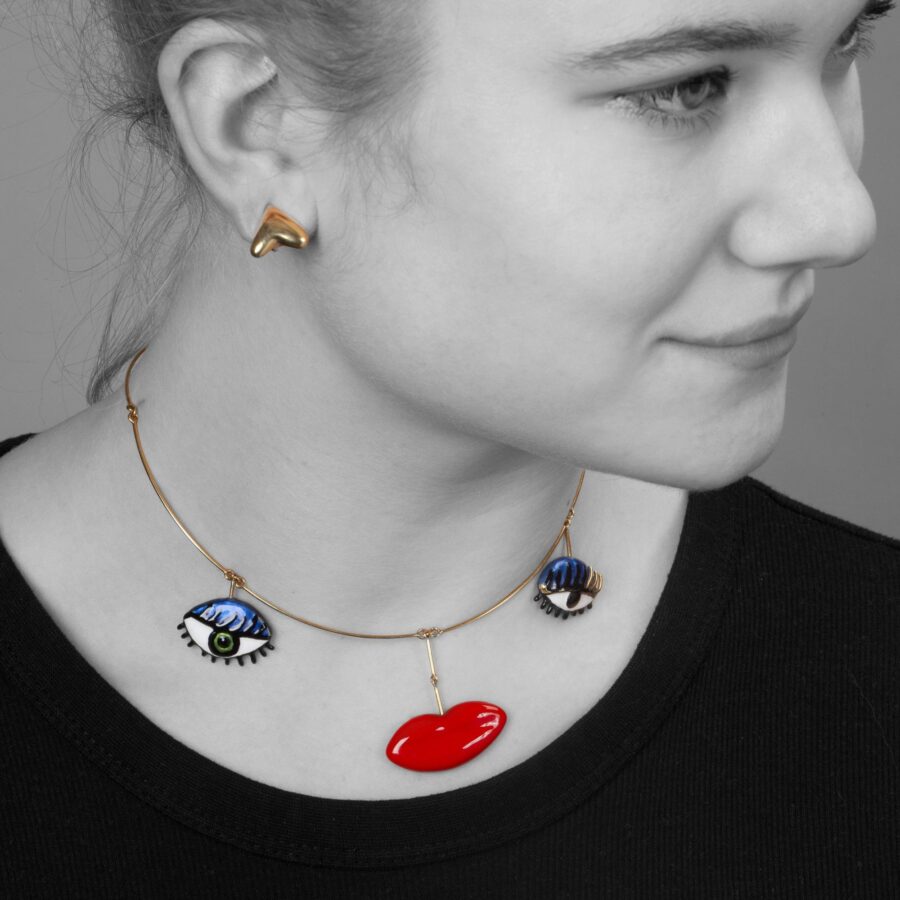 An eighteen carat yellow gold necklace with three pendants forming a face, with two pairs of matching earrings. Signed Niki de Saint Phalle, dated 1973.