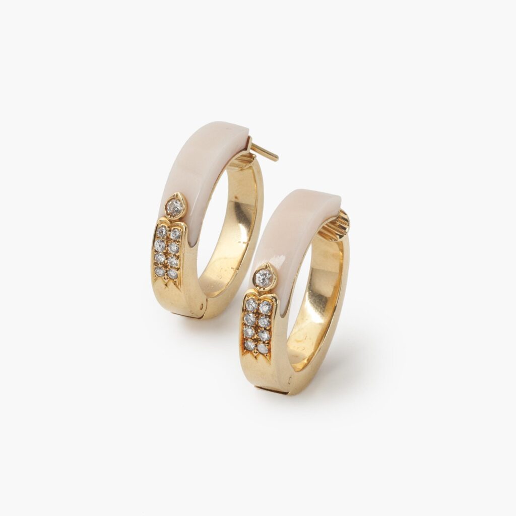 A pair of eighteen carat yellow gold hoop earrings, inlayed with peau d’ange coral,and set with diamonds. Signed Cartier, France and numbered. Made ca 1980. 