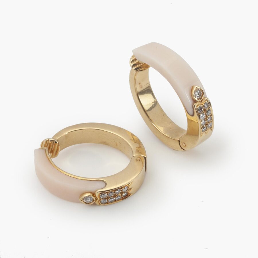 A pair of eighteen carat yellow gold hoop earrings, inlayed with peau d’ange coral,and set with diamonds. Signed Cartier, France and numbered. Made ca 1980. 