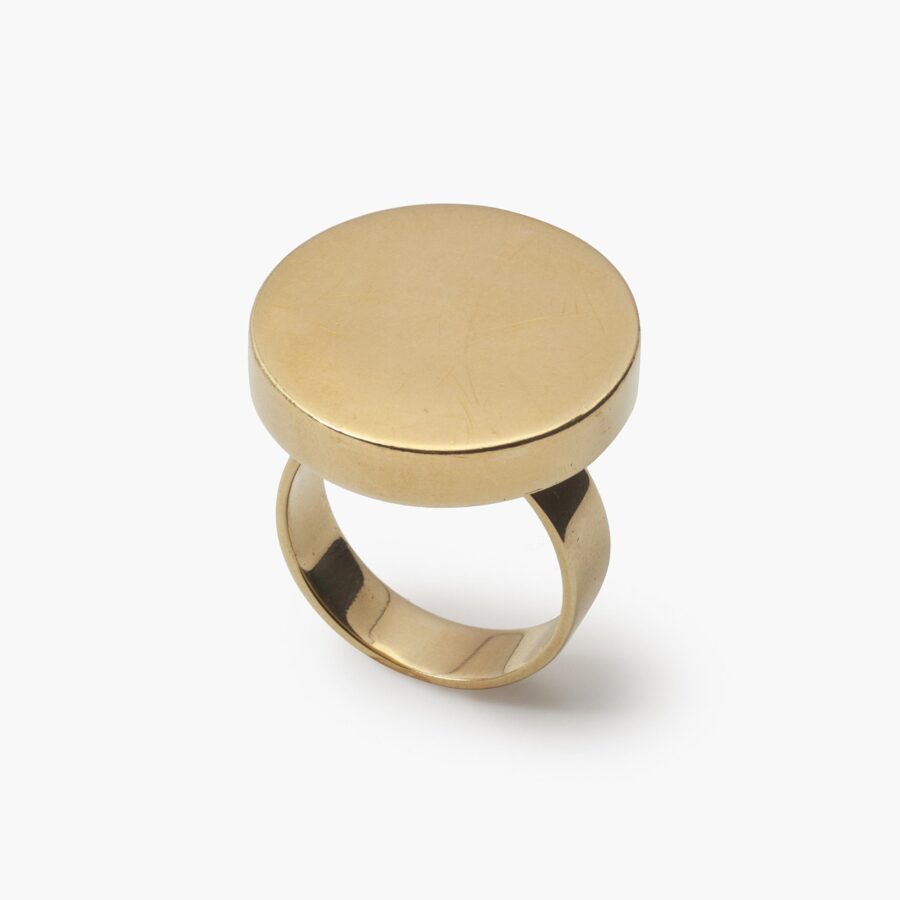 An eighteen carat yellow gold ring designed as a disc on a plain shank. Signed Jean Dinh Van for Cartier, made in New York, ca 1970 and numbered.