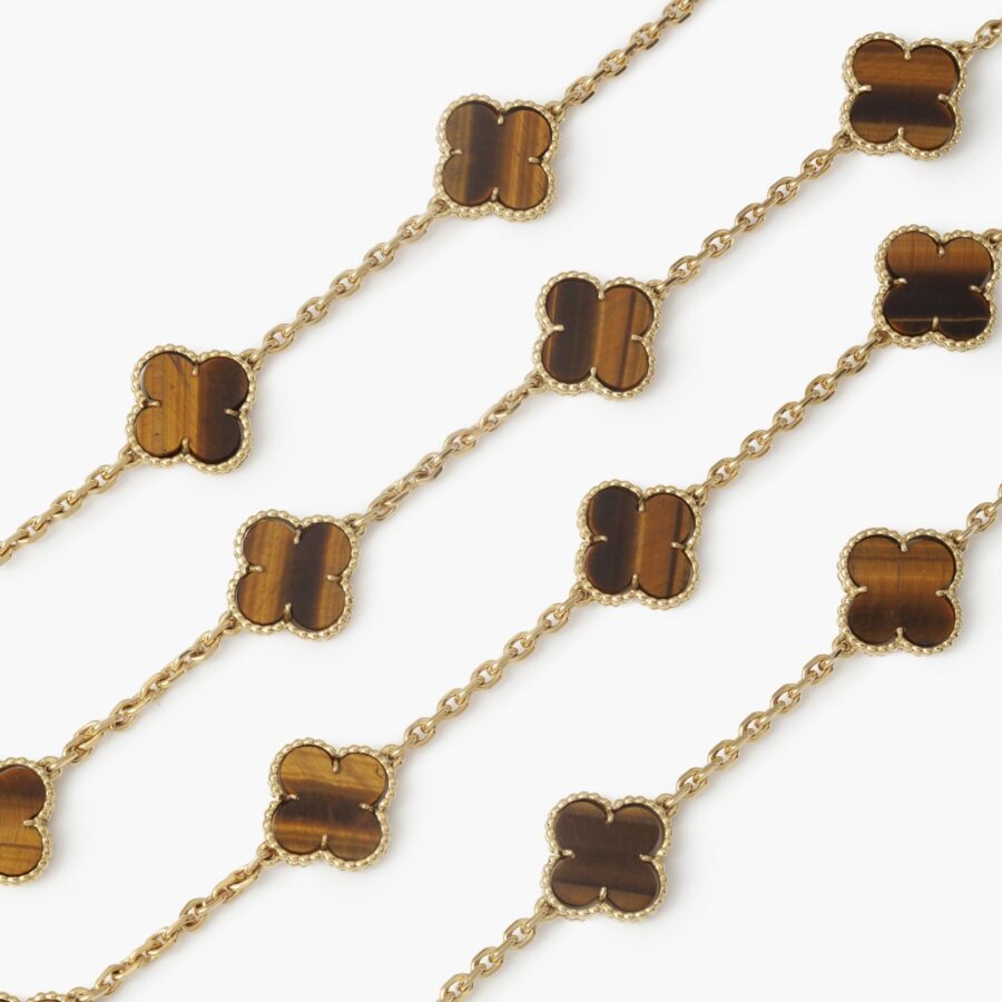 An eighteen carat yellow gold extra long “Alhambra” longchain of twentythree tiger’s eye “Alhambra” motifs. Signed Van Cleef & Arpels. Dated 1971. 